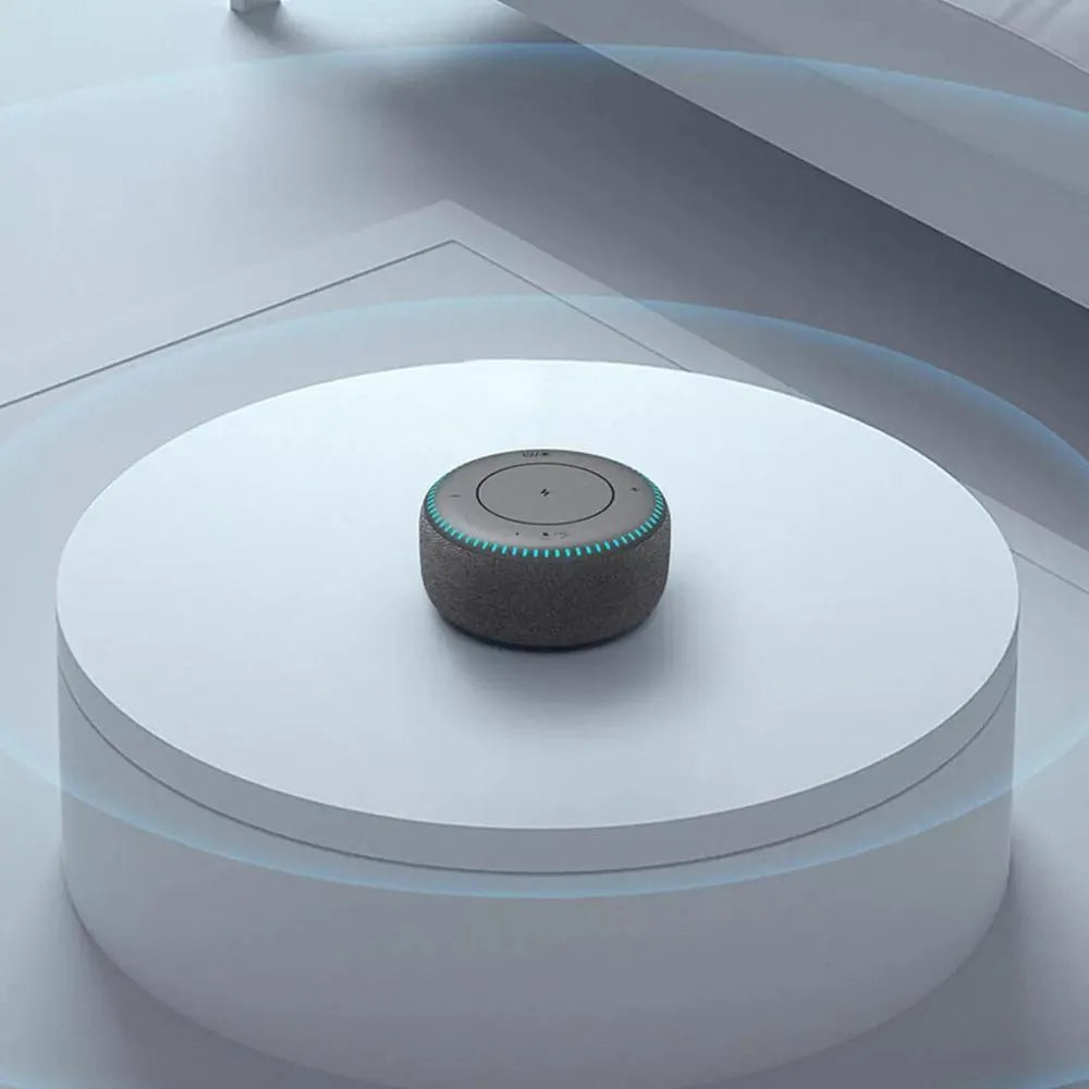 Black wireless charging Bluetooth speaker unit with USB port on a desktop.