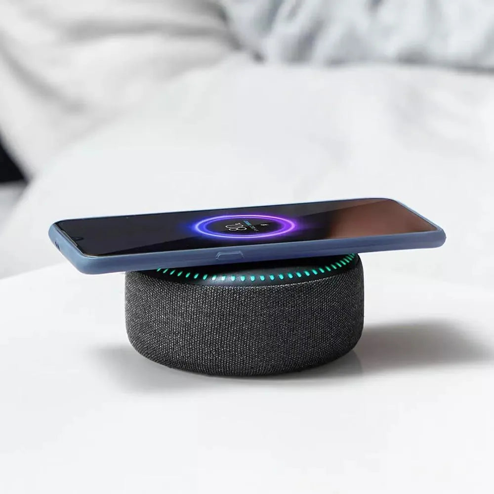 Black wireless charging Bluetooth speaker unit with USB port on a desktop.