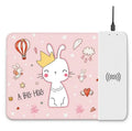 Black wireless charging mouse pad with RGB lighting and a cartoon design on a desk