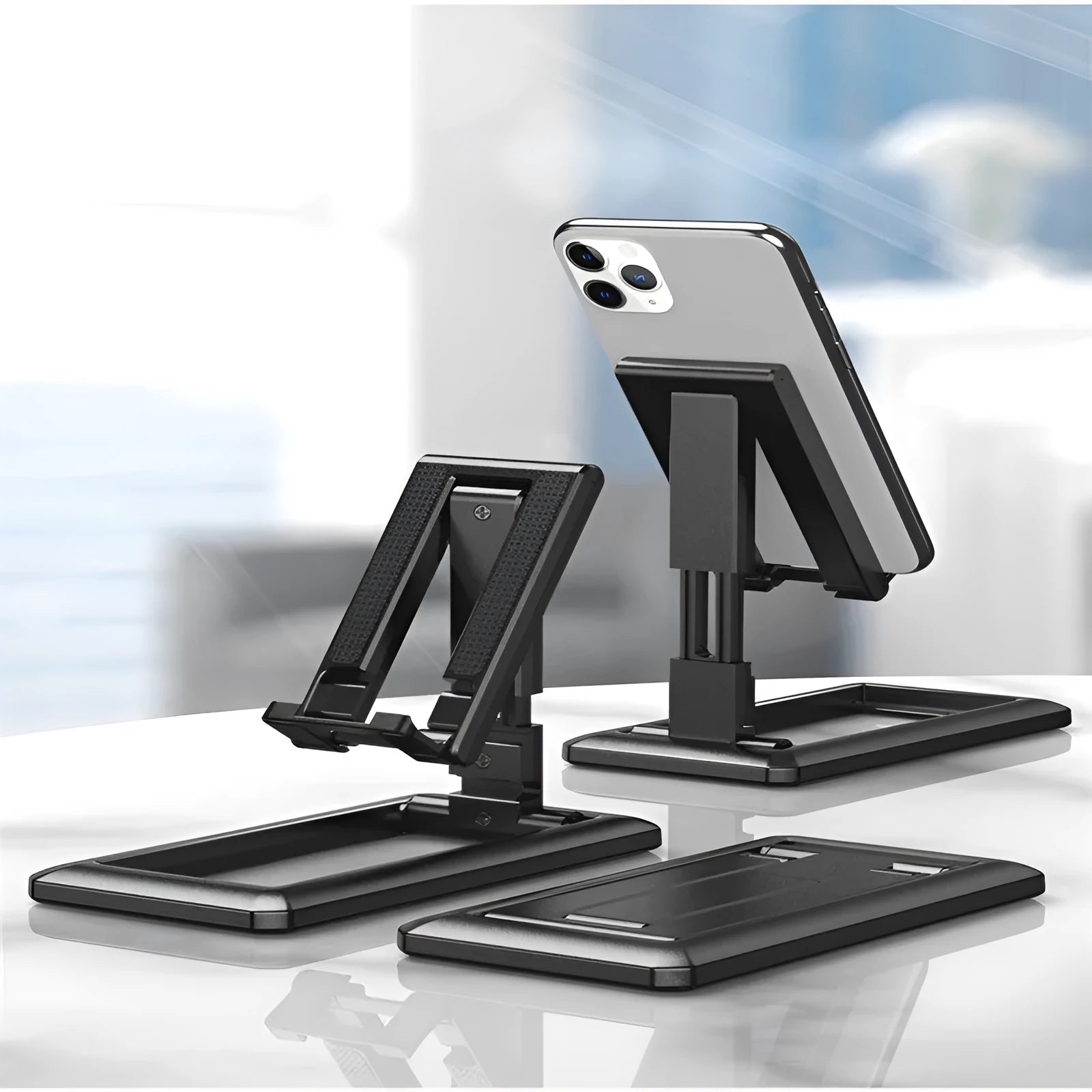 Retractable folding mobile phone stand in extended position on desktop