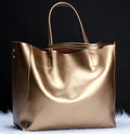 Cowhide leather women's handbag with shoulder strap in bronze colour, showing main compartment.