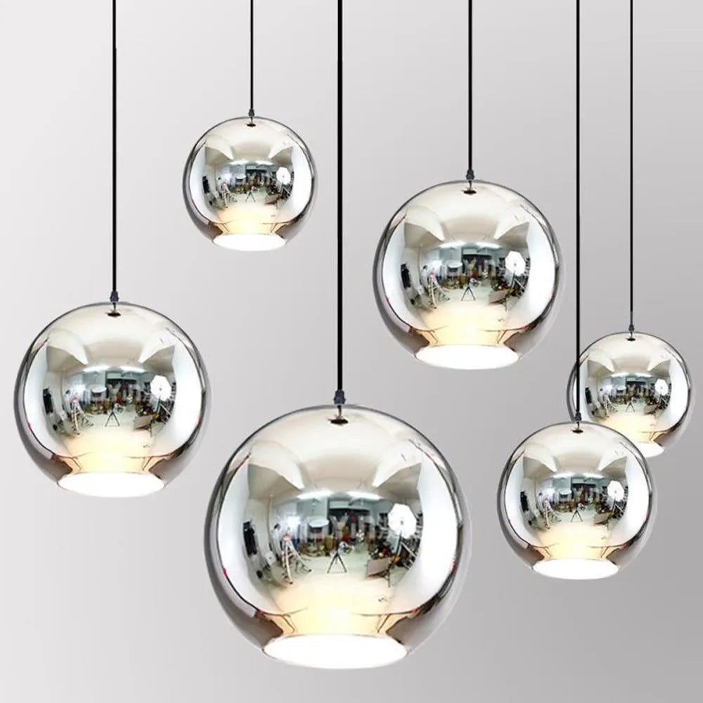 Round glass chandelier with an iron body in gold finish, hanging on an adjustable cord with LED light.