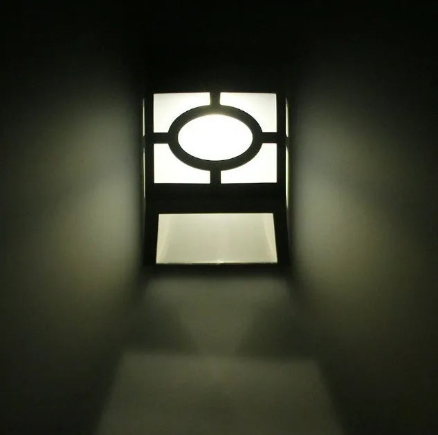 Retro-style white solar wall light with solar panel and two LEDs, shown next to a mounting screw.
