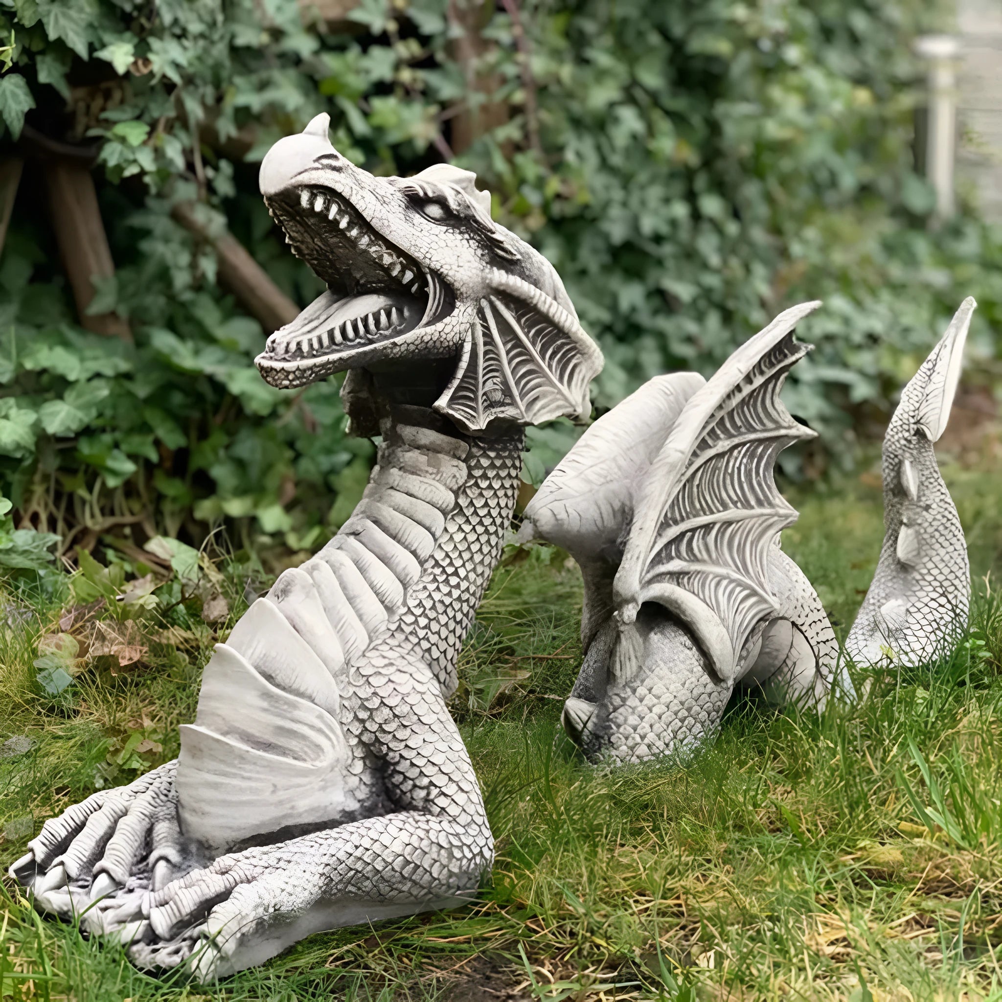 Large gothic dragon garden statue in charcoal gray stone with scales, wings, and tail, outdoor lawn decor