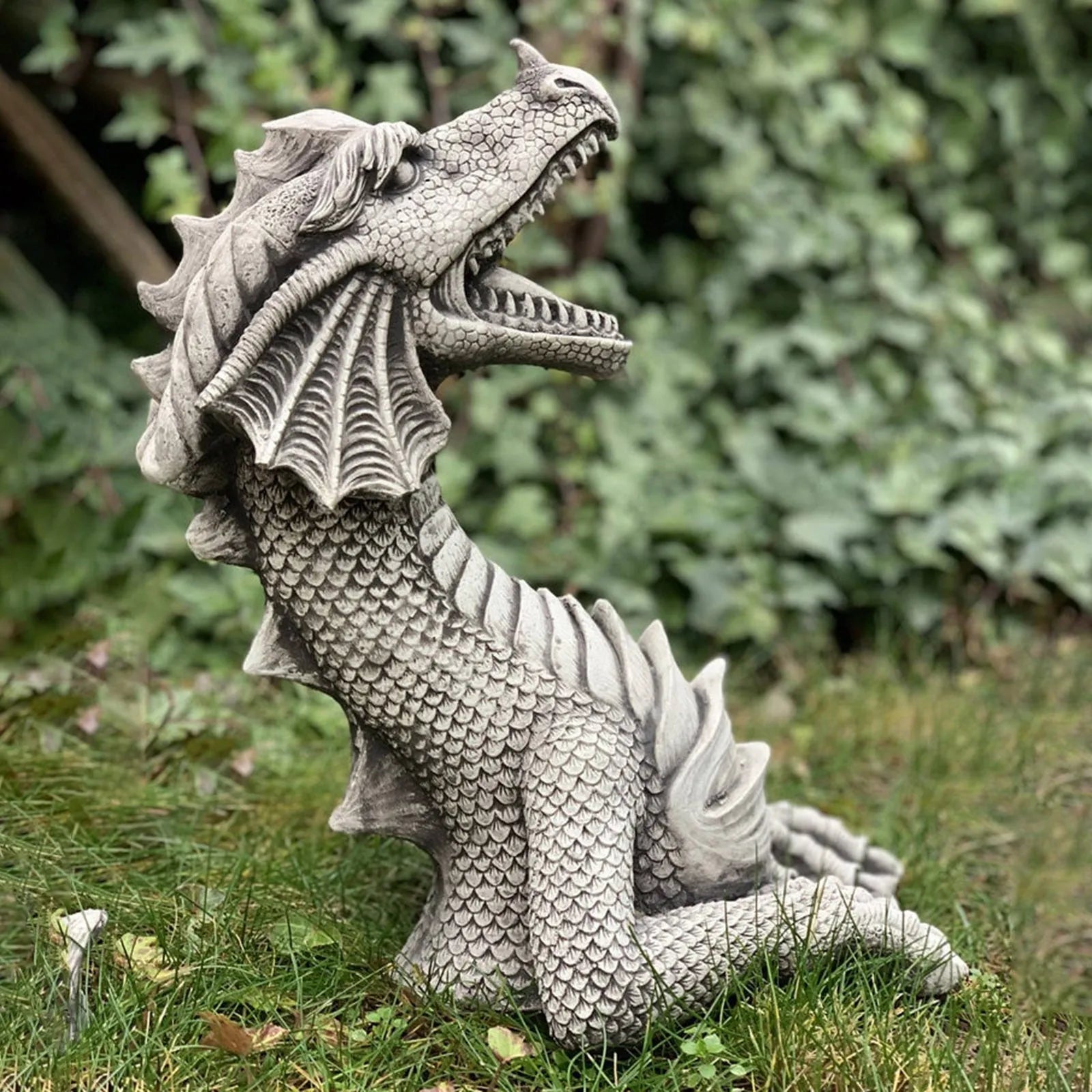 Large gothic dragon garden statue in charcoal gray stone with scales, wings, and tail, outdoor lawn decor