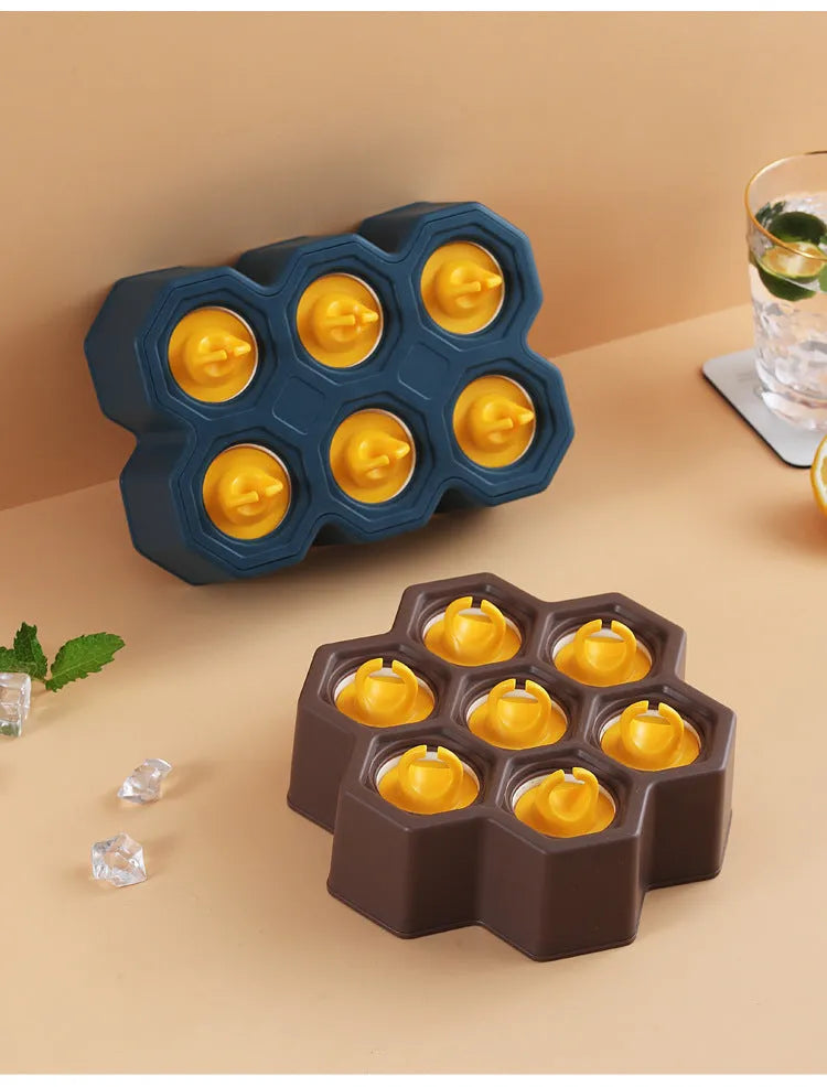 Brown plastic ice cube mold with honeycomb design and anti-drip edges
