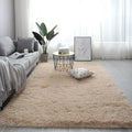 Large rectangle fluffy plush carpet in a neutral colour on a wooden floor.