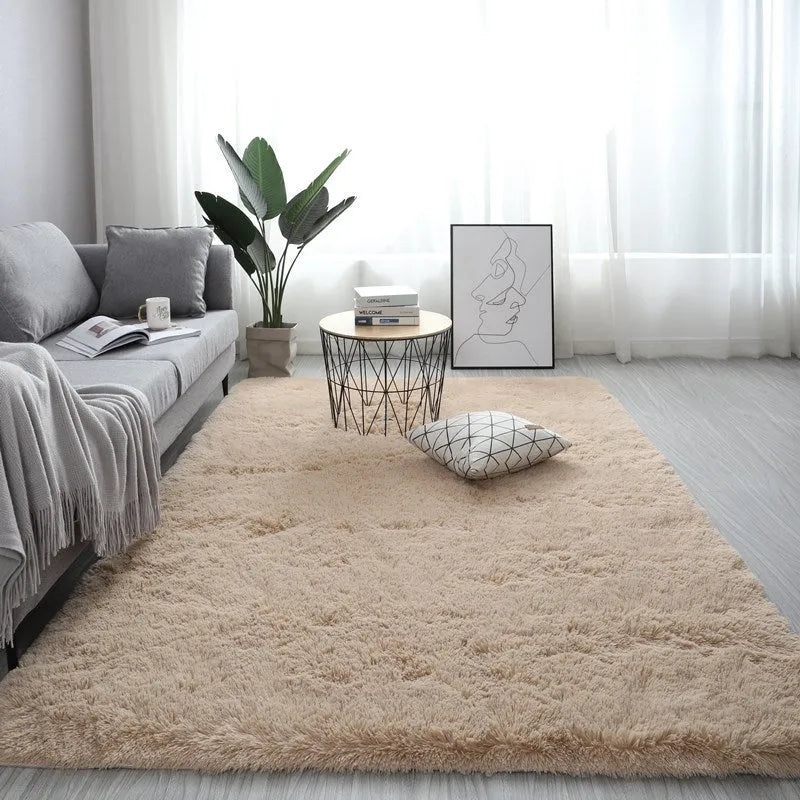 Large rectangle fluffy plush carpet in a neutral colour on a wooden floor.