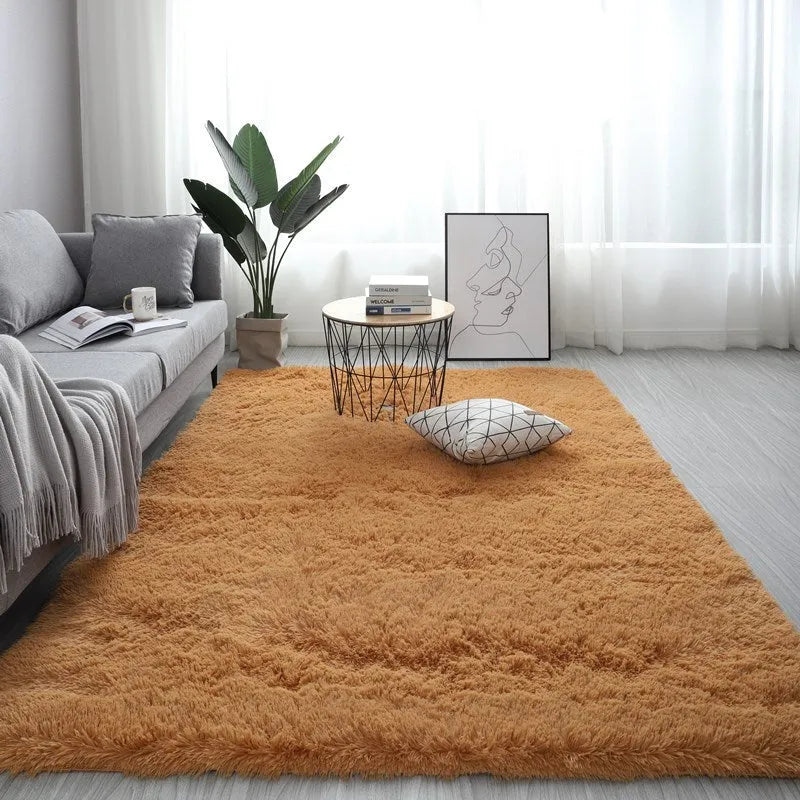 Large rectangle fluffy plush carpet in a neutral colour on a wooden floor.