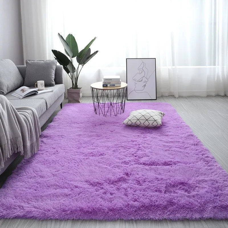 Large rectangle fluffy plush carpet in a neutral colour on a wooden floor.