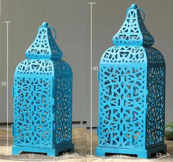 Blue geometric iron candelabra holding tealights on a wooden table.