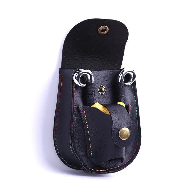 Leather slingshot belt bag in black, holding steel balls, attached to a belt for outdoor carry.