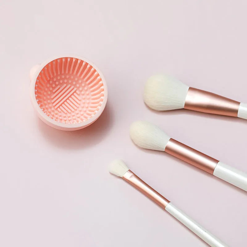 Small silicone makeup brush cleaning scrub tray in white with raised textured centre for removing foundation residue