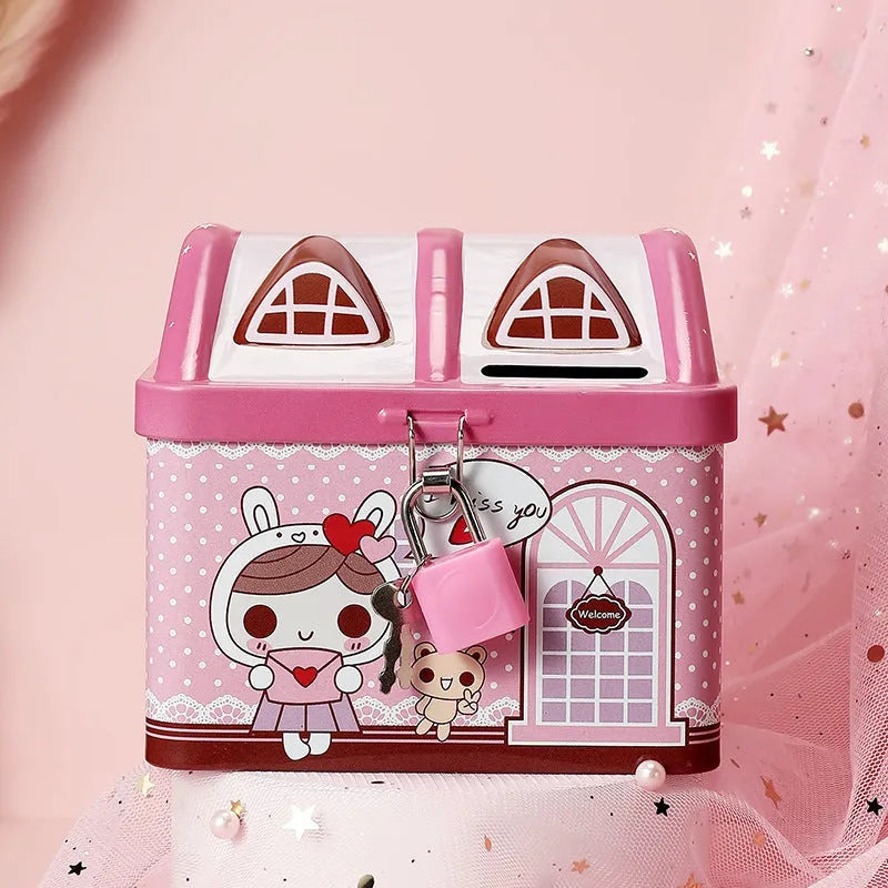 Blue and pink house-shaped tinplate piggy bank for coins on a wooden desk.