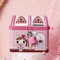 Blue and pink house-shaped tinplate piggy bank for coins on a wooden desk.
