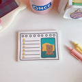 Kawaii bear cartoon design memo pad notebook open on a desk with a pen.