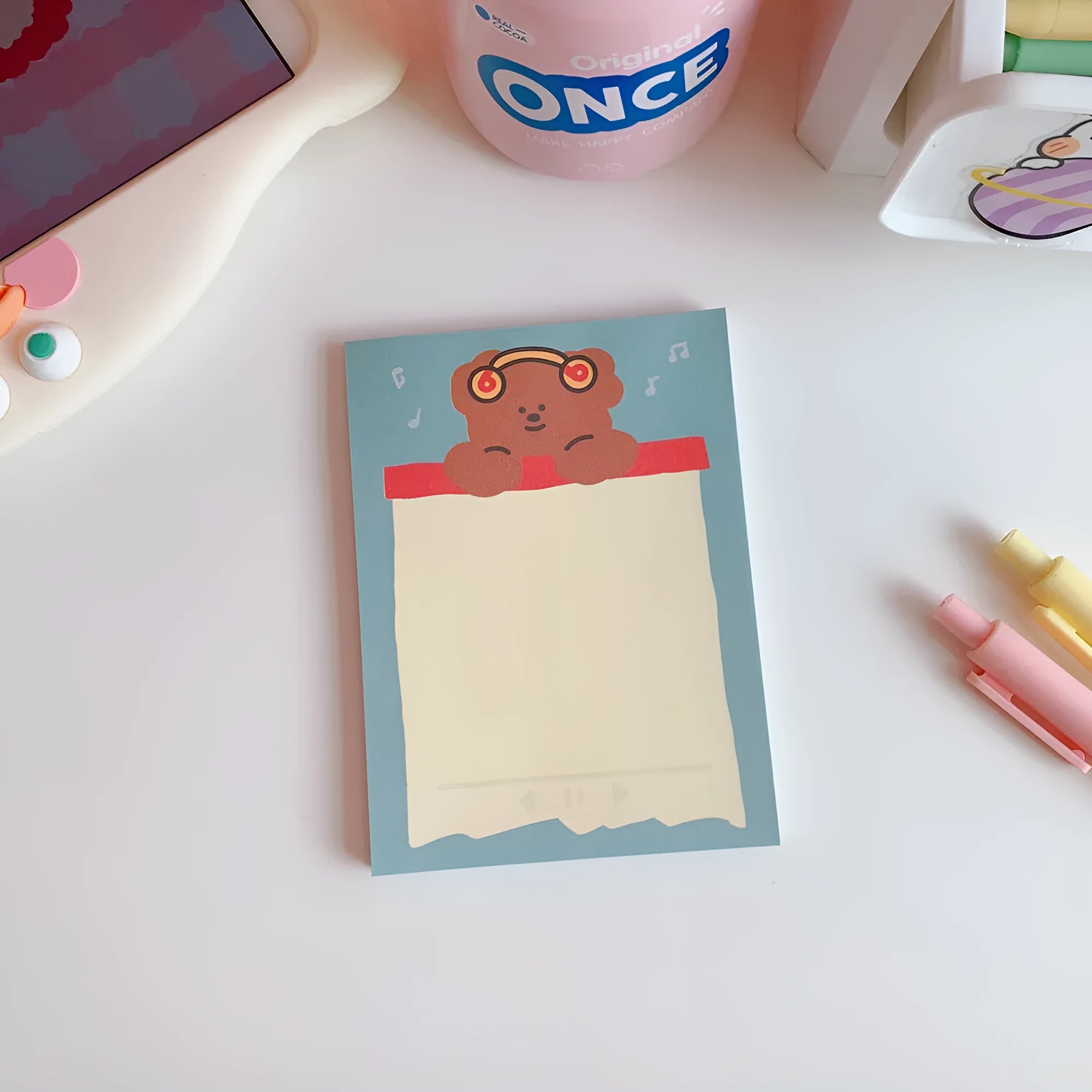 Kawaii bear cartoon design memo pad notebook open on a desk with a pen.