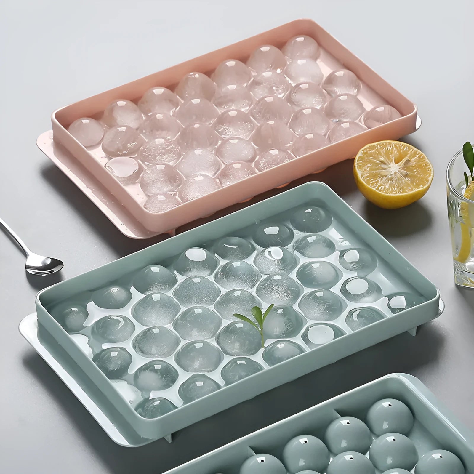 Sky blue and pink plastic round ice ball mould trays with 18 and 33 grids.