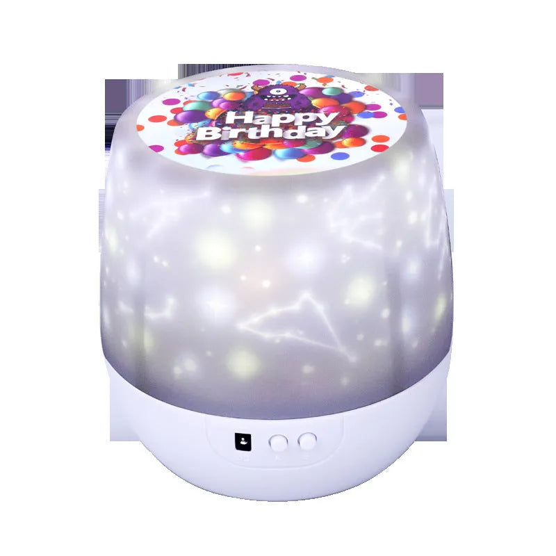 Compact white starry sky projector on a table, projecting blue constellation patterns onto a dark wall.