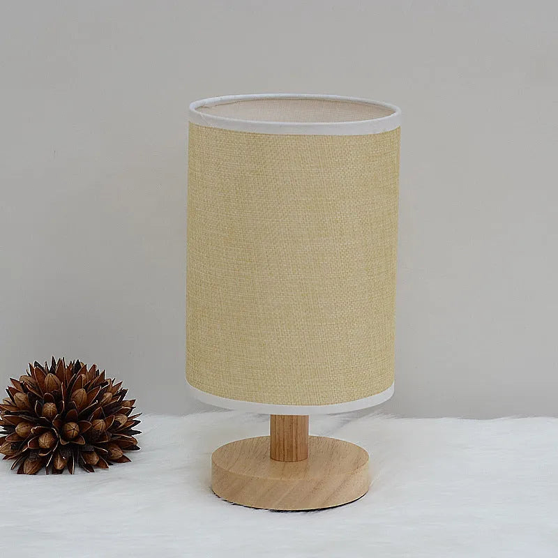 Solid wood cloth cover LED table lamp with grey linen shade and USB cable on a wooden desk