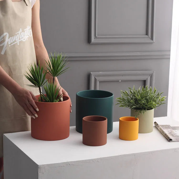 Cylindrical Nordic style ceramic succulent planter with drainage hole on wooden table