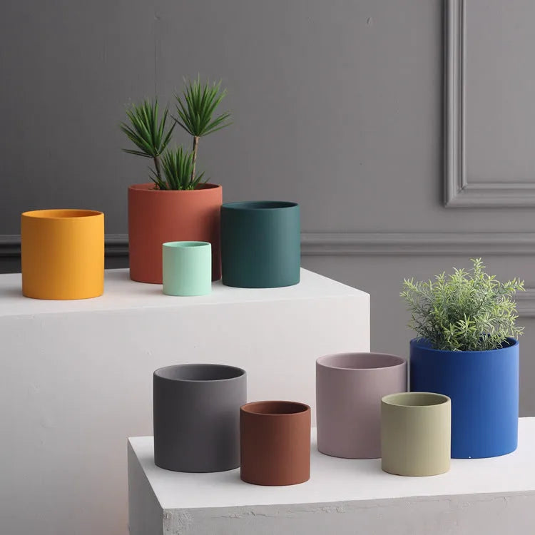 Cylindrical Nordic style ceramic succulent planter with drainage hole on wooden table
