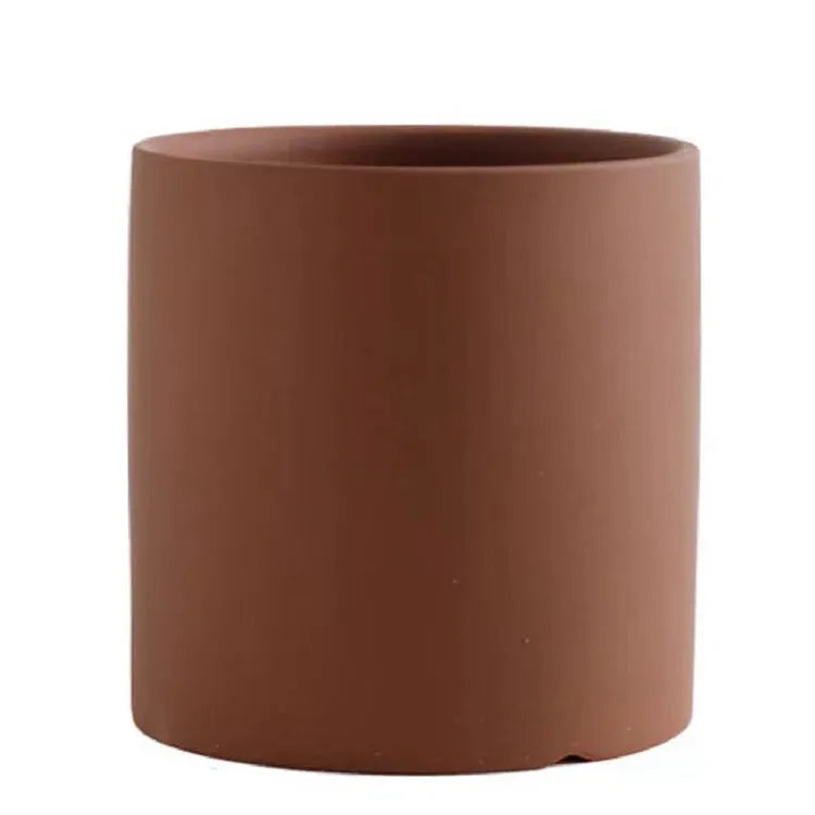 Cylindrical Nordic style ceramic succulent planter with drainage hole on wooden table