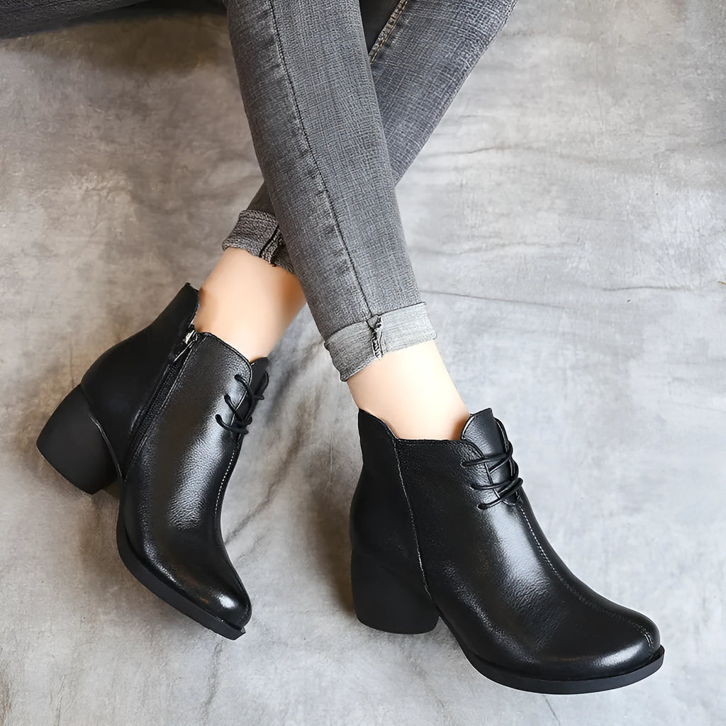 Black women's leather Martin boots with a thick heel and round toe on a white background.