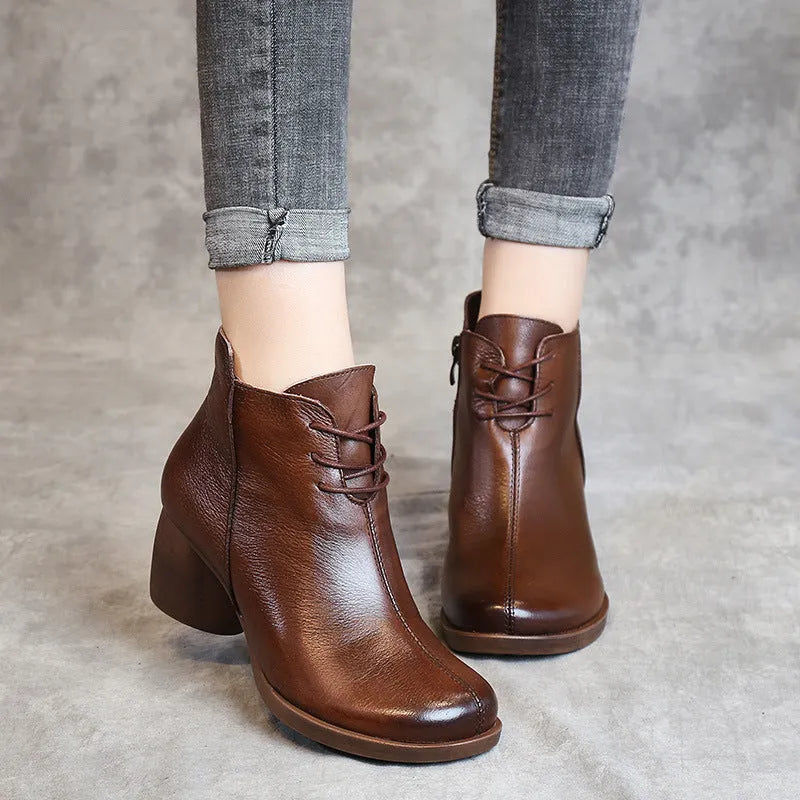Black women's leather Martin boots with a thick heel and round toe on a white background.