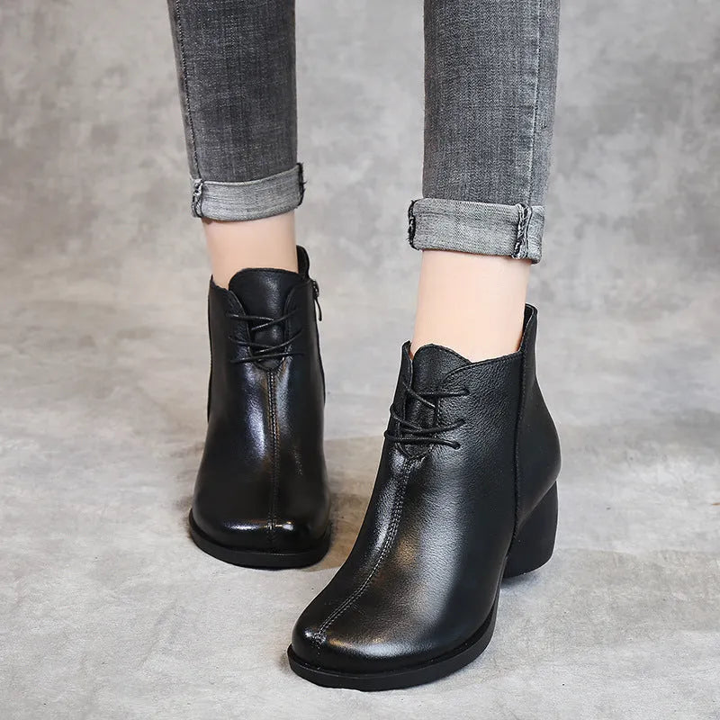 Black women's leather Martin boots with a thick heel and round toe on a white background.