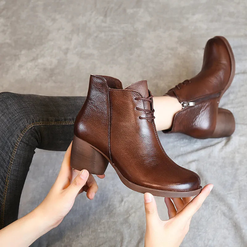 Black women's leather Martin boots with a thick heel and round toe on a white background.