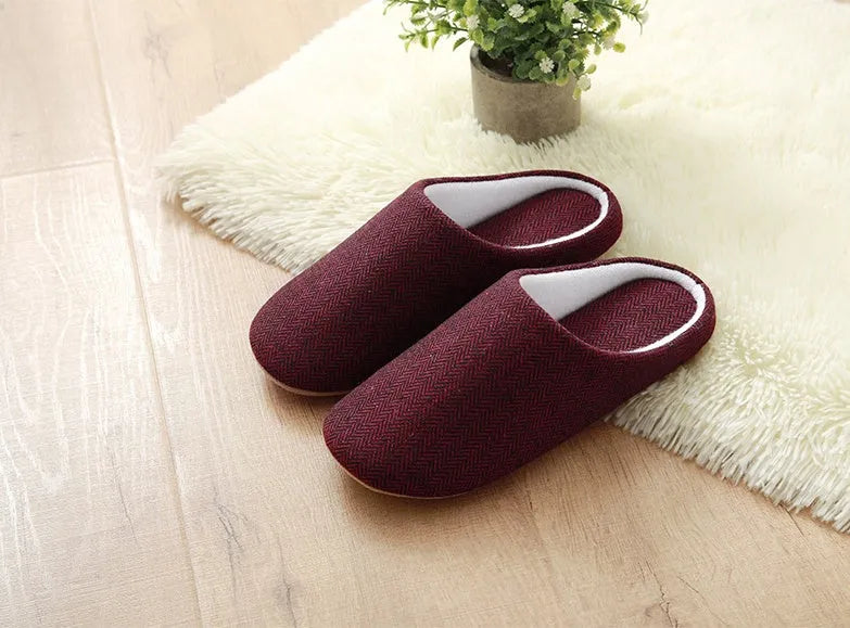 Men's cotton black indoor slippers with anti-skid sole on a home floor