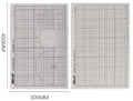 Green A3 self-healing cutting mat with centimetre grid lines on a desk.