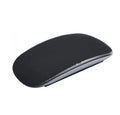 Silicone Magic Mouse cover skin in black on a white desk next to an Apple Magic Mouse