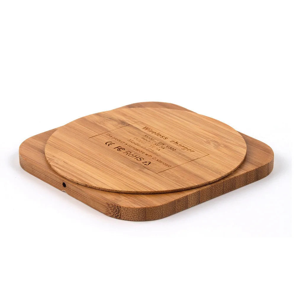 Brown heart-shaped wooden bamboo 5W Qi wireless charging pad on a desk