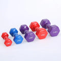 Brightly coloured plastic fitness dumbbells on a floor, showing glossy surface and multiple weight options.
