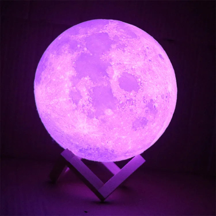 3D printed white moon lamp glowing on a wooden stand, showing detailed lunar craters.