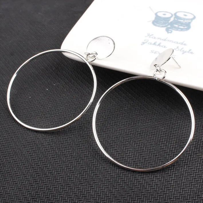 Large circle gold alloy hoop earrings with diamond-cut finish on white background