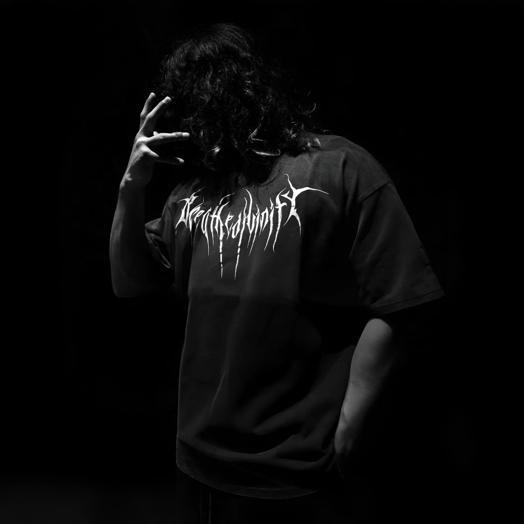 Man wearing a dark coloured, loose-fit pure cotton short-sleeved t-shirt with a gilding detail.