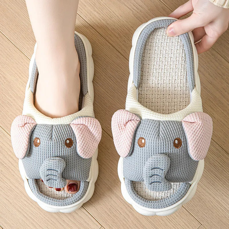 A pair of elephant grey open-toe linen slippers for couples on a plain background.