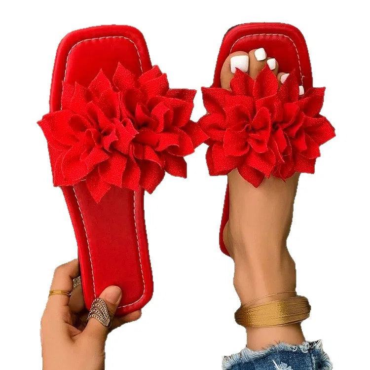 Women's flat flip-flops with flower detail on PU upper, available in apricot, black, white, red, and green