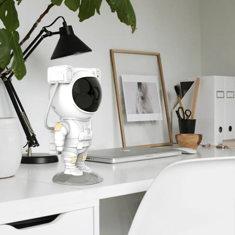 Creative astronaut galaxy starry sky projector nightlight on a table with nebula and star effects displayed against a dark background
