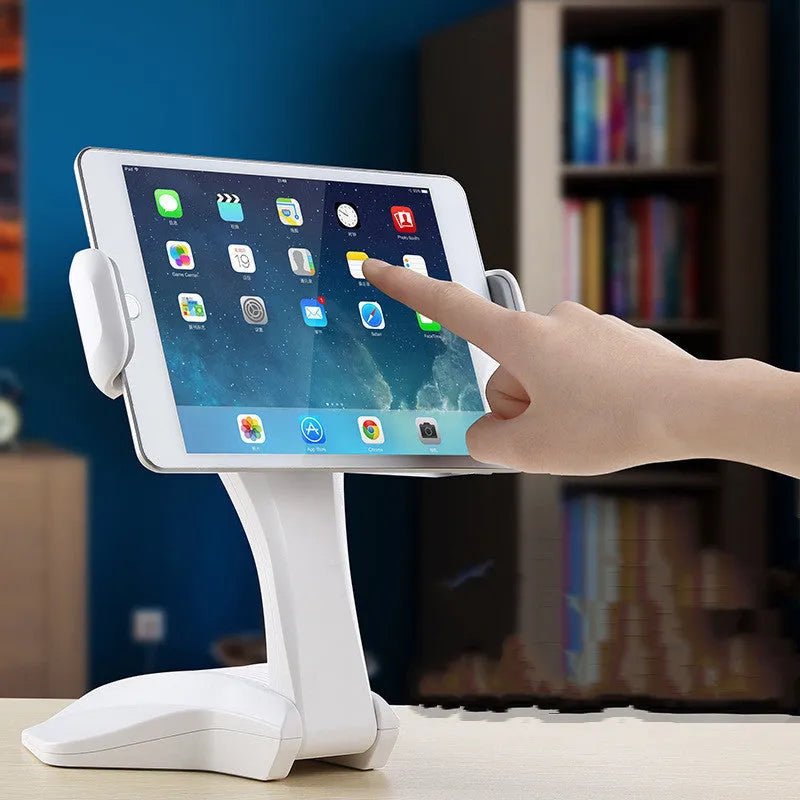 White adjustable tablet support stand with clip extended, holding a tablet on a desk.