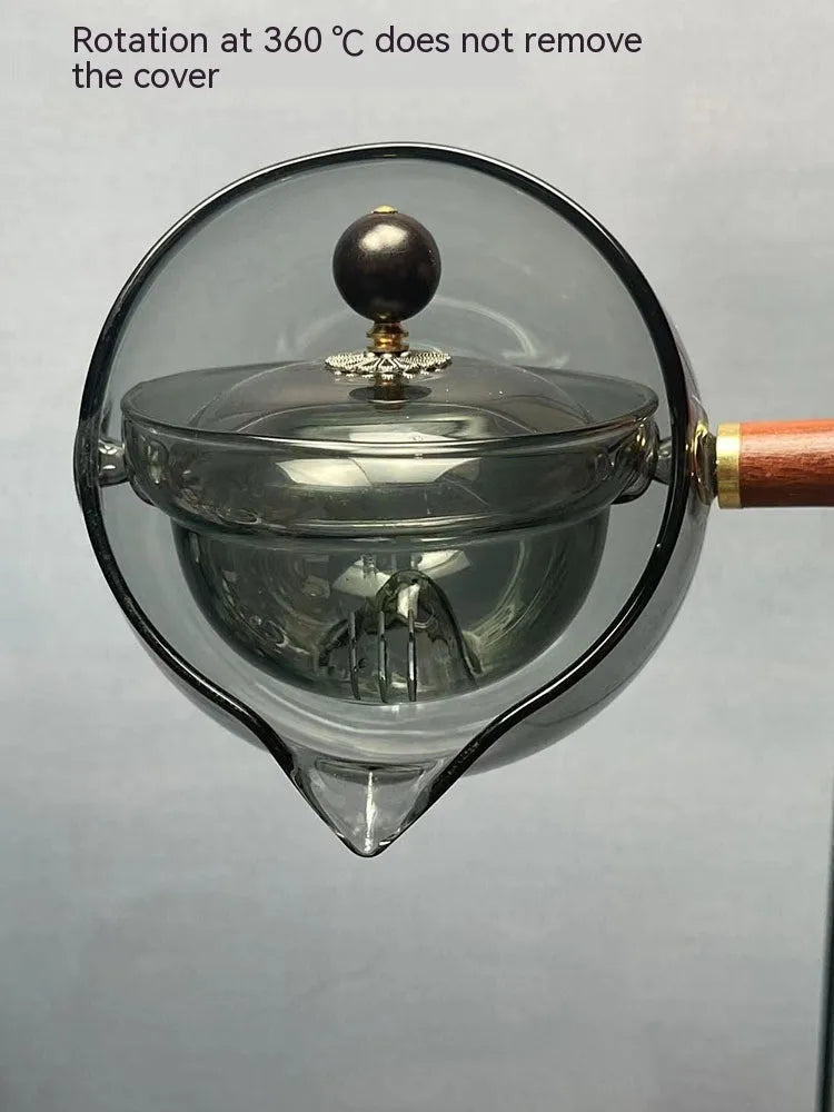 Transparent borosilicate glass teapot with wooden handle and infuser on rotary base