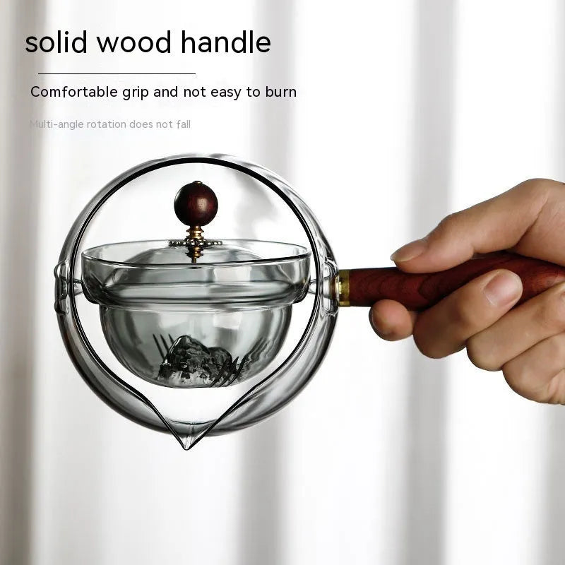 Transparent borosilicate glass teapot with wooden handle and infuser on rotary base