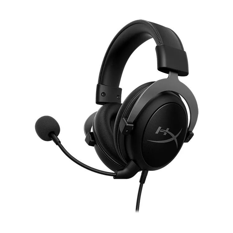 Black and red wired over-ear gaming headset with detachable microphone on a desk next to a USB sound card remote control.
