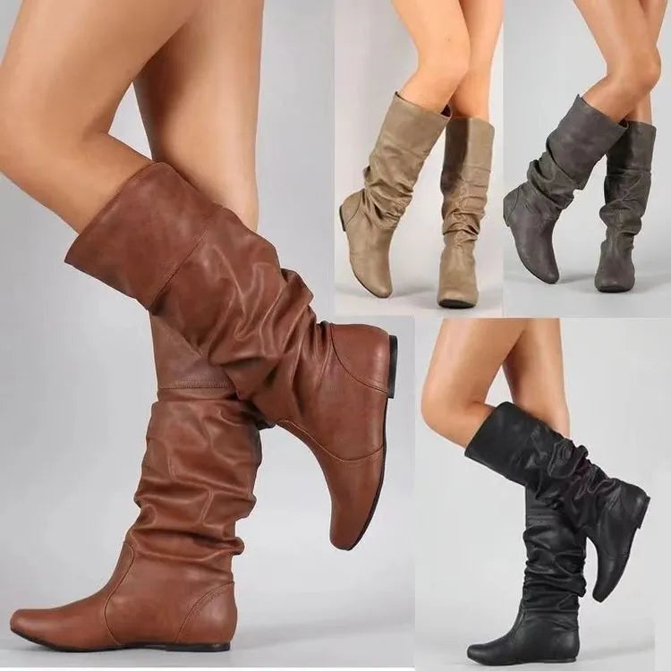 Women's black flat slip-on boots with round toe and high shaft on a white background.