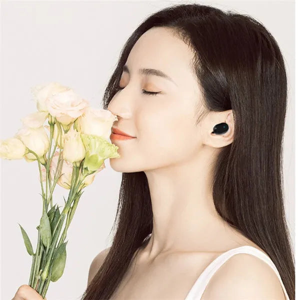 Black and white M1 wireless Bluetooth earbuds with a charging case on a table.