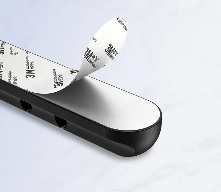 Black organic silicone desktop cable manager clips holding USB cables on a desk
