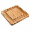 Square bamboo cutting board in wood colour with four knives and forks arranged on top